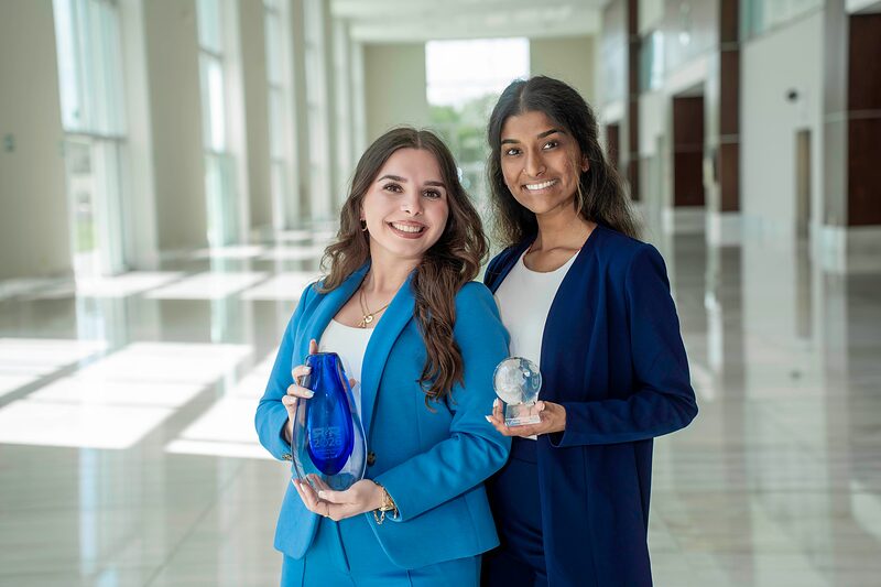 O.W.E Team representatives holding client recognition awards